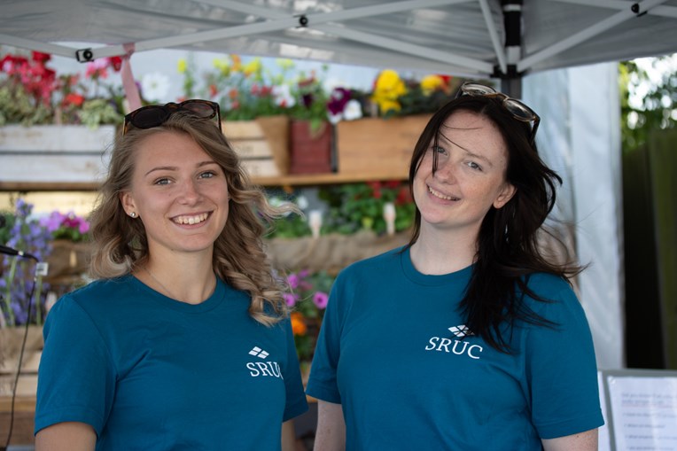 Two young women smile at the camera