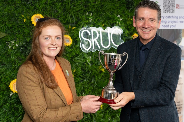 A man and woman hold a trophy