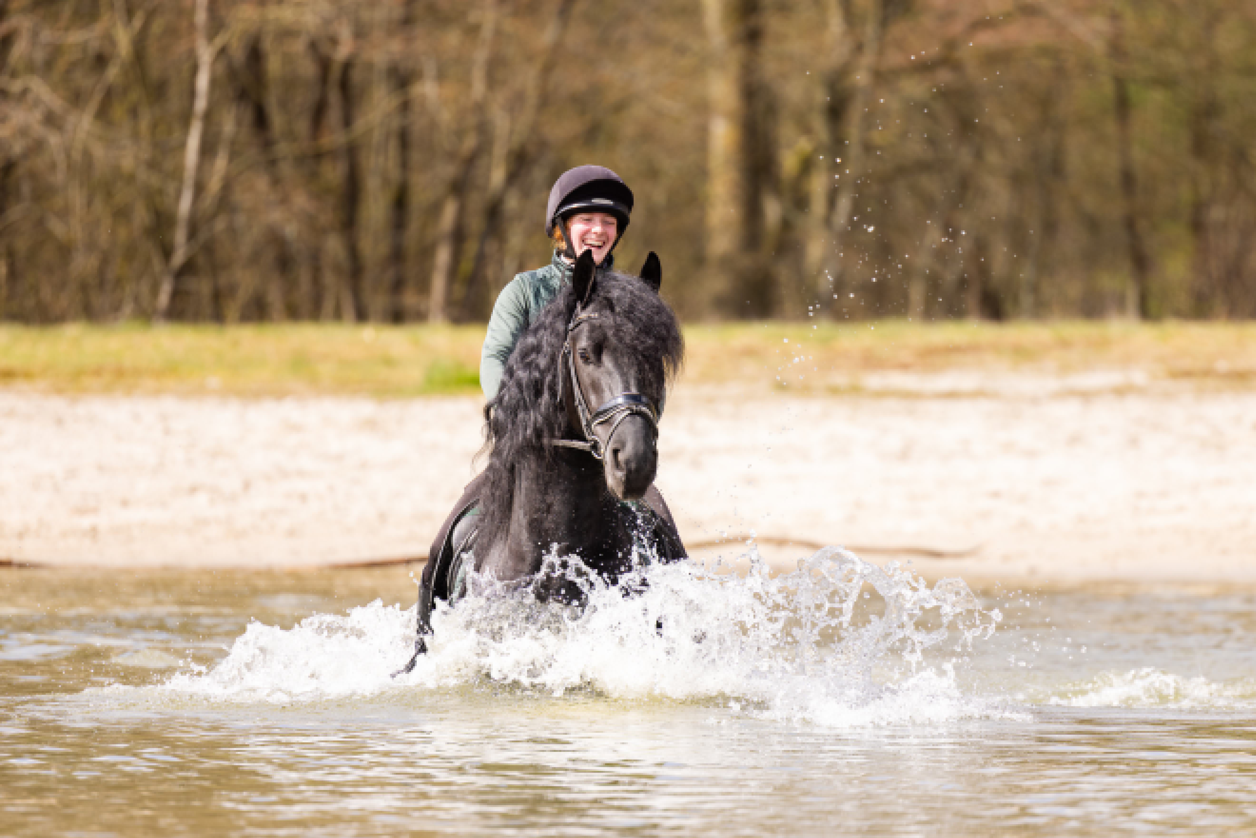 Woman riding a horse through water