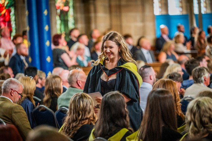 a girl walks through graduation after receiving her award