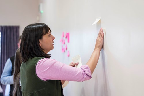 Woman putting post notes on a wall