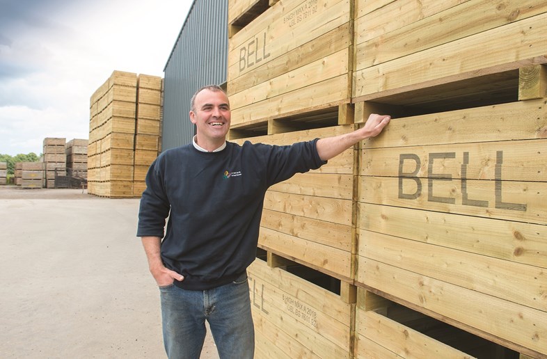 Man standing in front of wooden pallets