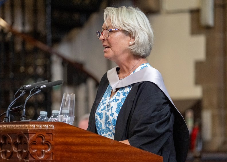 Woman speaking into a microphone at a graduation