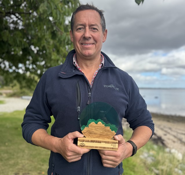A man standing holding an award