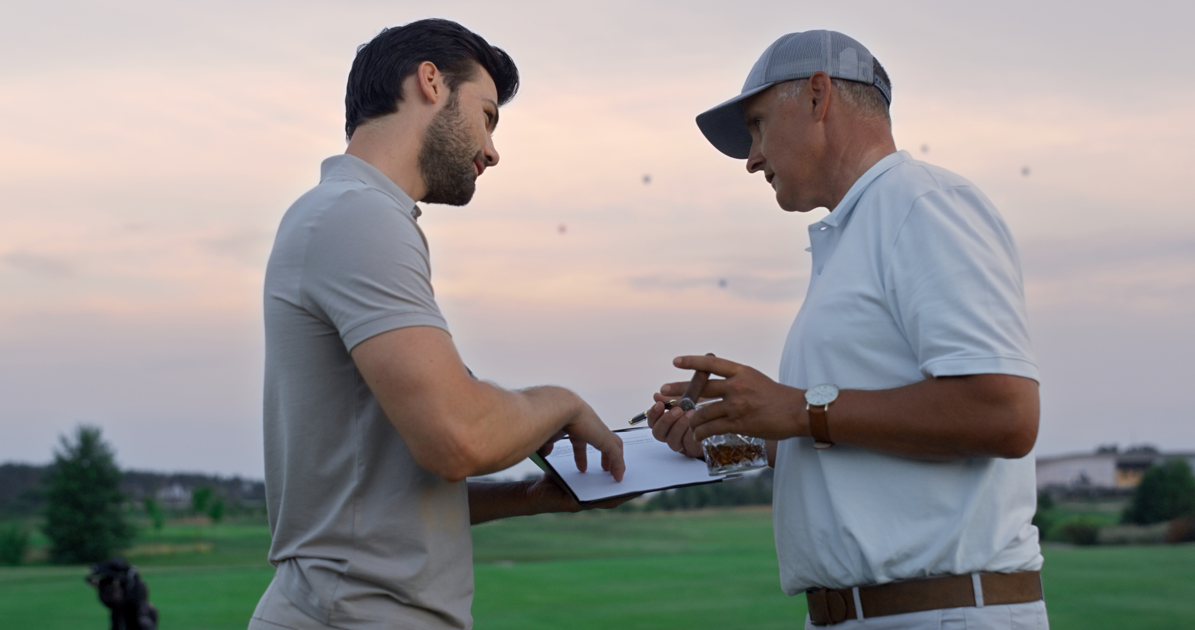 Two men talking, on a golf course