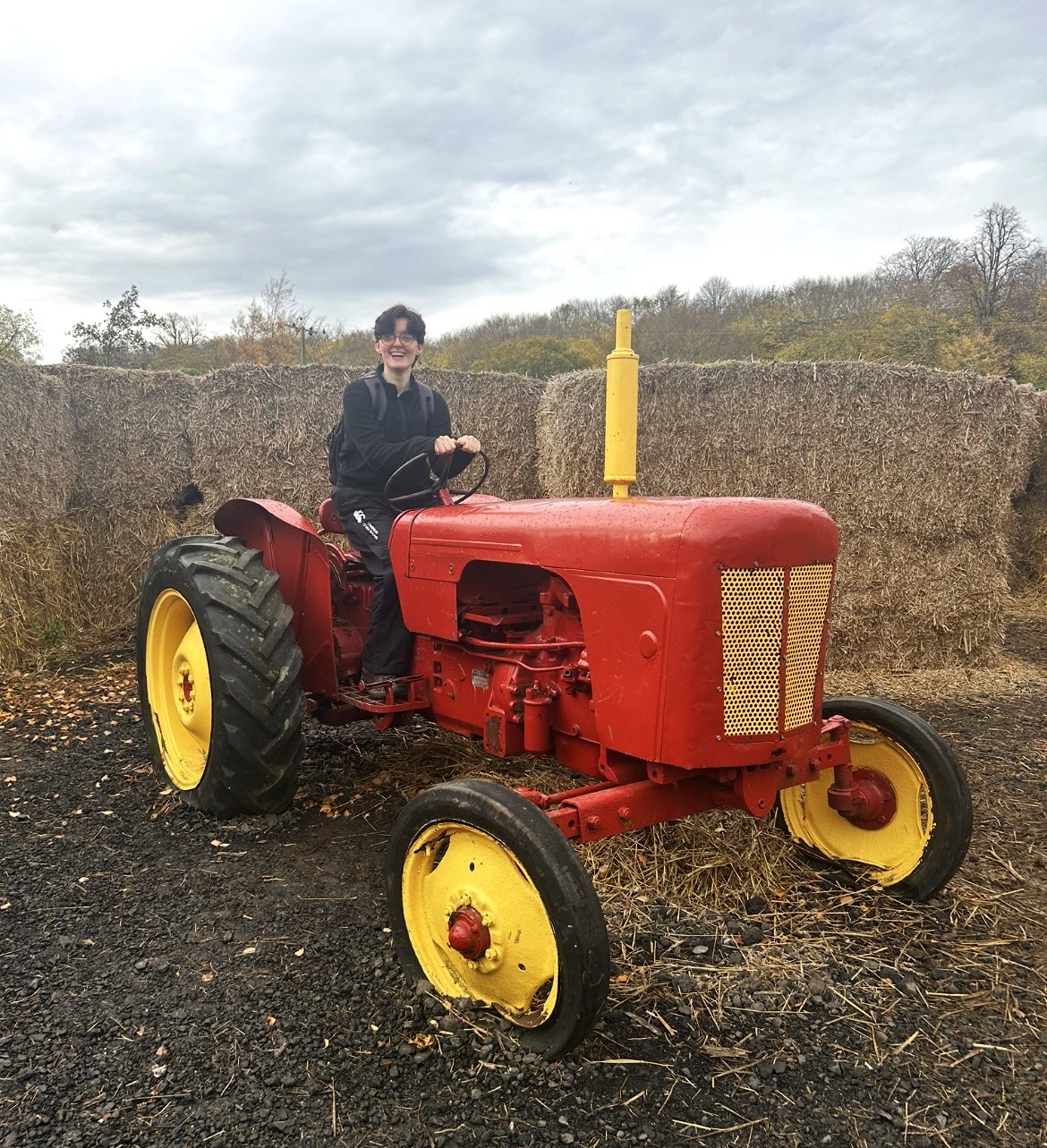 Young person sitting on an antique tractor