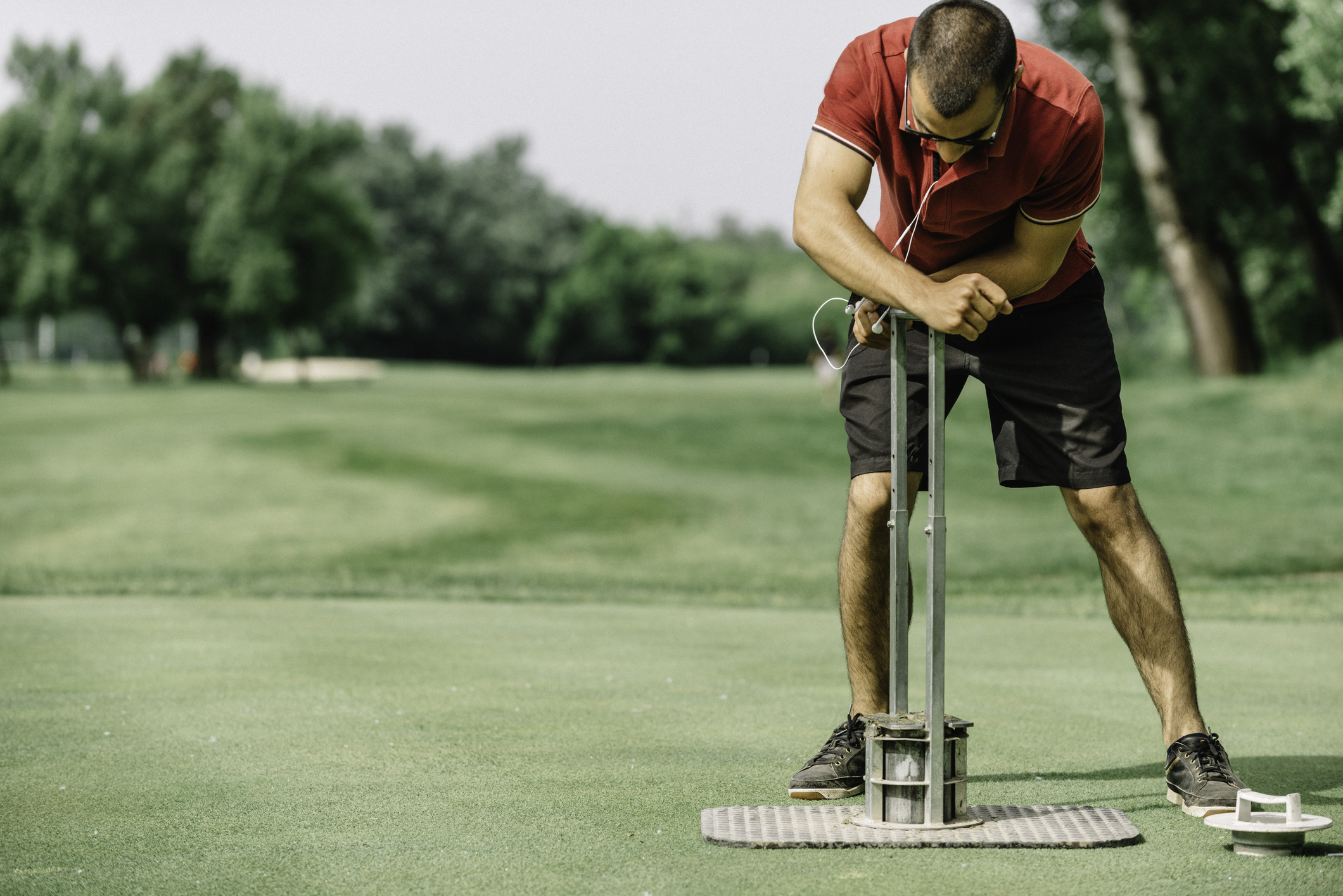 Greenkeeper cutting a hole on a golf course