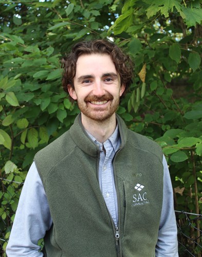 A photo of Brady Stevents smiling with trees in background